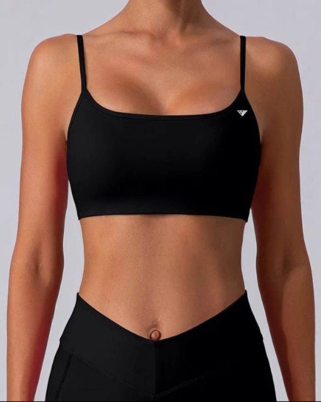 BD WEAR Mira crop top in black, featuring a fitted design and sleeveless style, shown on a model.